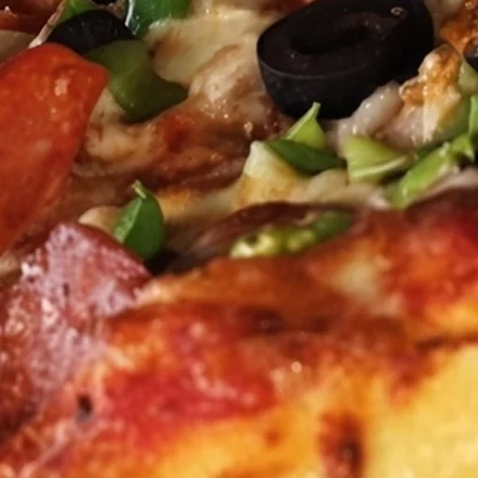 Wood-oven pizza with pepperoni, olives and peppers